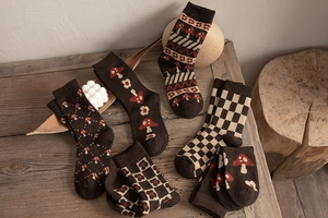 Macro view of brown vintage wool socks with mushroom patterns and checkerboard knits