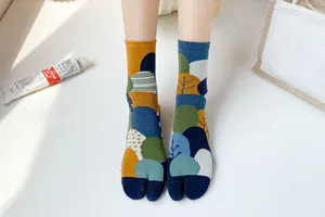 Close-up of artistic split-toe tabi socks with forest patterns and forest green tones