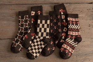 Detailed view of various vintage brown thermal wool socks with patterns on wood