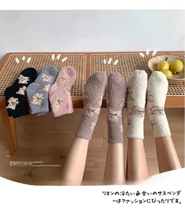 Detail of five pairs of thick coral fleece winter socks with cute cartoon bear patterns