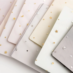 Detailed view of sheer mesh fabric samples with gold star and moon patterns in various colors