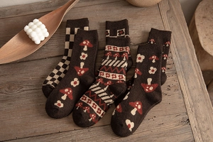 Detailed view of four pairs of thick wool socks with vintage mushroom and floral patterns