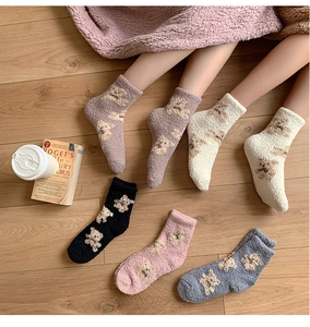 Close-up of thick coral fleece socks with cute bear patterns and warm plush texture