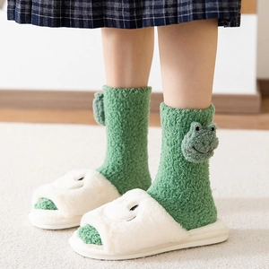 Cute green coral fleece frog socks and white plush slippers for winter indoor warmth