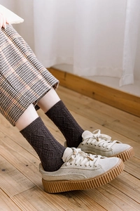 Detail of winter wool socks in coffee diamond pattern paired with beige sneakers