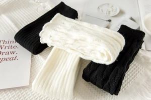 Detailed knit texture of cable-stitch leg warmers in black and cream white colors
