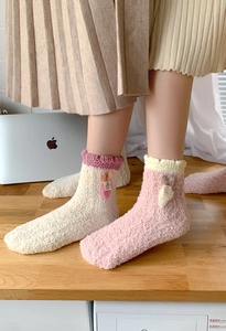 Close-up of thick coral fleece sleep socks with 3D carrot decor and soft ruffled cuffs