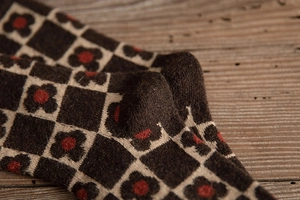 Close-up of thick wool socks featuring retro brown checkered patterns and floral details