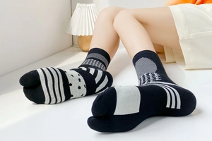 Detail of black and white patterned tabi socks with a split-toe design in a cozy setting