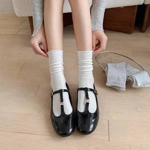 Classic black patent leather Mary Jane shoes with T-strap and white jacquard socks