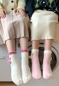 Close-up of thick coral fleece winter socks with cute bows and wavy edges for women