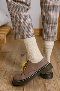 Detail of wool socks with diamond pattern paired with brown vintage leather boots