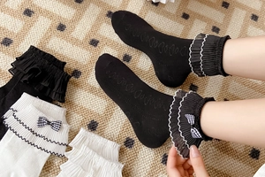 Detailed view of sweet Lolita socks with layered lace trim and plaid bow accents