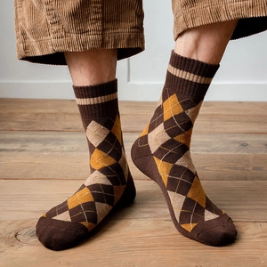 Détail de chaussettes à losanges marron et orange avec revers côtelés élastiques