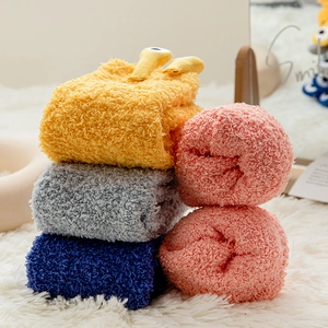 Close-up of thick coral fleece socks in multiple colors with cute 3D cartoon eyes