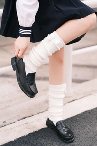 Detailed knit texture and satin bow accent on white leg warmers for JK uniforms