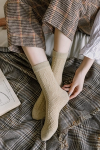 Detailed close-up of retro diamond knit wool socks in beige for winter comfort