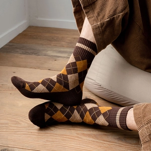 Gros plan de chaussettes à losanges de style britannique marron et jaune à texture épaisse