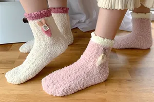 Close-up of coral fleece socks with 3D bunny ears and carrot design for winter warmth