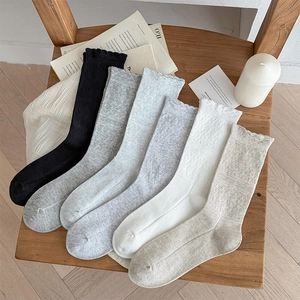 6 pairs of women's cotton lace socks with diamond patterns in neutral colors on wood chair