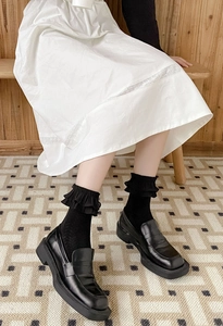 Close-up of black frilly lolita socks paired with vintage chunky platform loafers