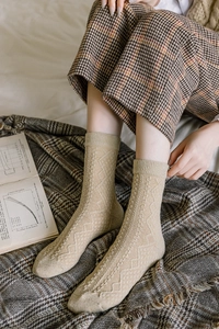 Close-up of beige wool socks with vintage argyle knit patterns and ribbed cuffs