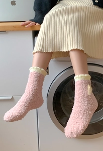Detail of pink coral fleece socks featuring yellow frilled edges and cute side bows
