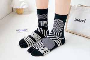 Detail view of Tabi socks featuring black and white geometric patterns and split toe design