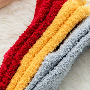 Close-up of soft coral fleece socks in red, yellow and grey with warm plush texture