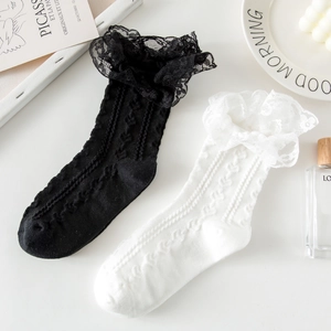 Detailed view of white and black lace socks with 3D jacquard patterns and ruffled edges