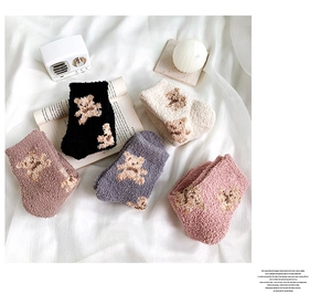Detail of five pairs of thick thermal coral fleece socks with cute bear patterns