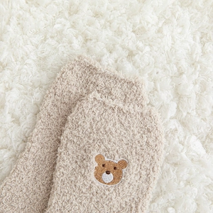 Gros plan sur une chaussette d'hiver en polaire corail avec broderie d'ours mignon