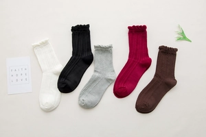 Detailed knit texture and ruffle cuffs of colorful mid-calf cotton crew socks for women