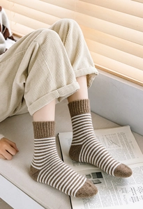 Détail de chaussettes rayées marron et blanc avec pointe renforcée et bord côtelé