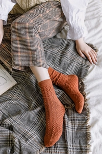 Detail of caramel knit mid-calf socks featuring a retro diamond lattice pattern texture
