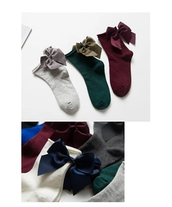 Dettaglio di calzini stile Lolita con grandi fiocchi di raso in vari colori eleganti