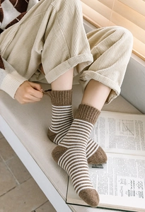 Gros plan de chaussettes rayées marron en tricot épais chaud pour l'hiver