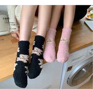 Detail of plush coral fleece winter socks in black and pink with cute bear patterns