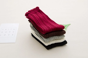Detailed texture of mid-calf cotton socks with vintage hollow patterns and wavy cuffs