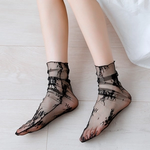 Close-up of black lace socks featuring intricate floral embroidery and sheer mesh texture