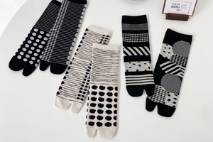 Close-up of four pairs of cotton tabi socks with geometric patterns in black and white