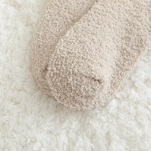 Gros plan de chaussettes en velours corail beige avec texture pelucheuse et chaude