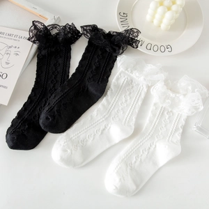 Close-up of sweet JK style white and black lace trim cotton socks on a white desk