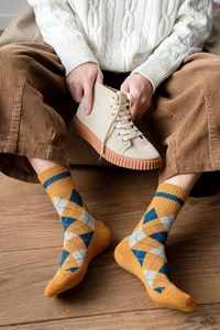 Gros plan de chaussettes en tricot jaune à losanges avec pantalon en velours côtelé