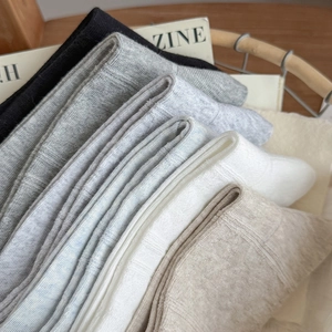 Detailed macro view of assorted pastel ribbed knit socks neatly folded in a bamboo basket