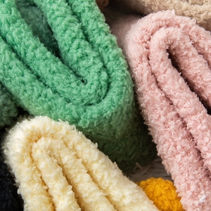 Macro detail of plush coral fleece fabric showing soft texture and multiple warm colors