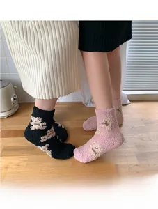 Detail of plush coral fleece thermal socks featuring cute cartoon bear patterns and thick texture