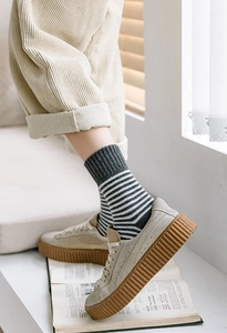 Détail de chaussettes rayées d'hiver avec baskets à plateforme en daim beige style rétro