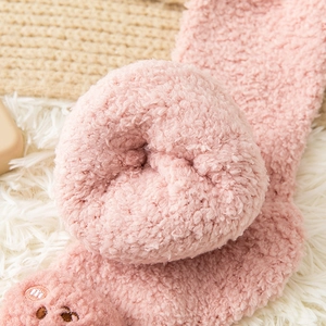 Close-up of thick pink coral fleece socks featuring cute bear embroidery detail