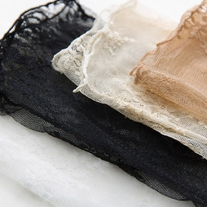 Macro detail of delicate floral lace textures in black, white, beige and brown tones